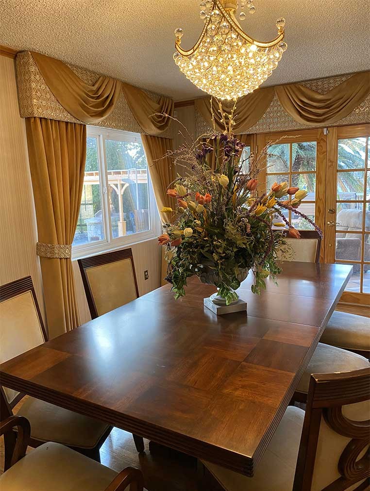 A luxurious dining room with a large chandelier and flower vase